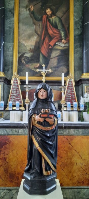 Die Statue der Heiligen Ottilia als Nonne. Sie hält ein Buch in den Händen mit zwei Augen darauf. Die Heilige Ottilia gilt als Schutzpatronin der Blinden und des Augenlichts. Diese Statue befindet sich in der Ottilien-Kapelle in Buttisholz LU