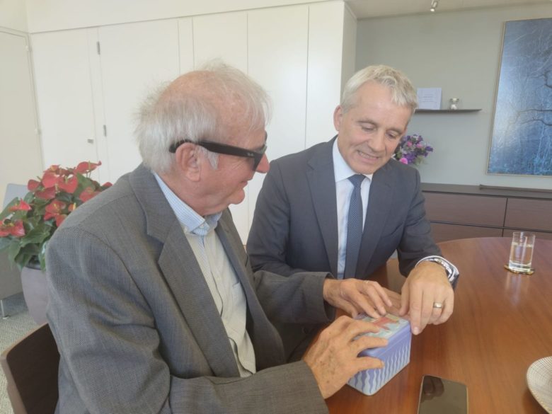 Le conseiller fédéral Jans a remis aux visiteurs de l'école des pommes une boîte de Läckerli de Bâle en guise de cadeau. La particularité de cette boîte est que son couvercle est orné d'une représentation en relief de l'hôtel de ville de Bâle et qu'en tirant sur une languette, on peut reproduire le son de la cloche de l'ancien tramway bâlois.